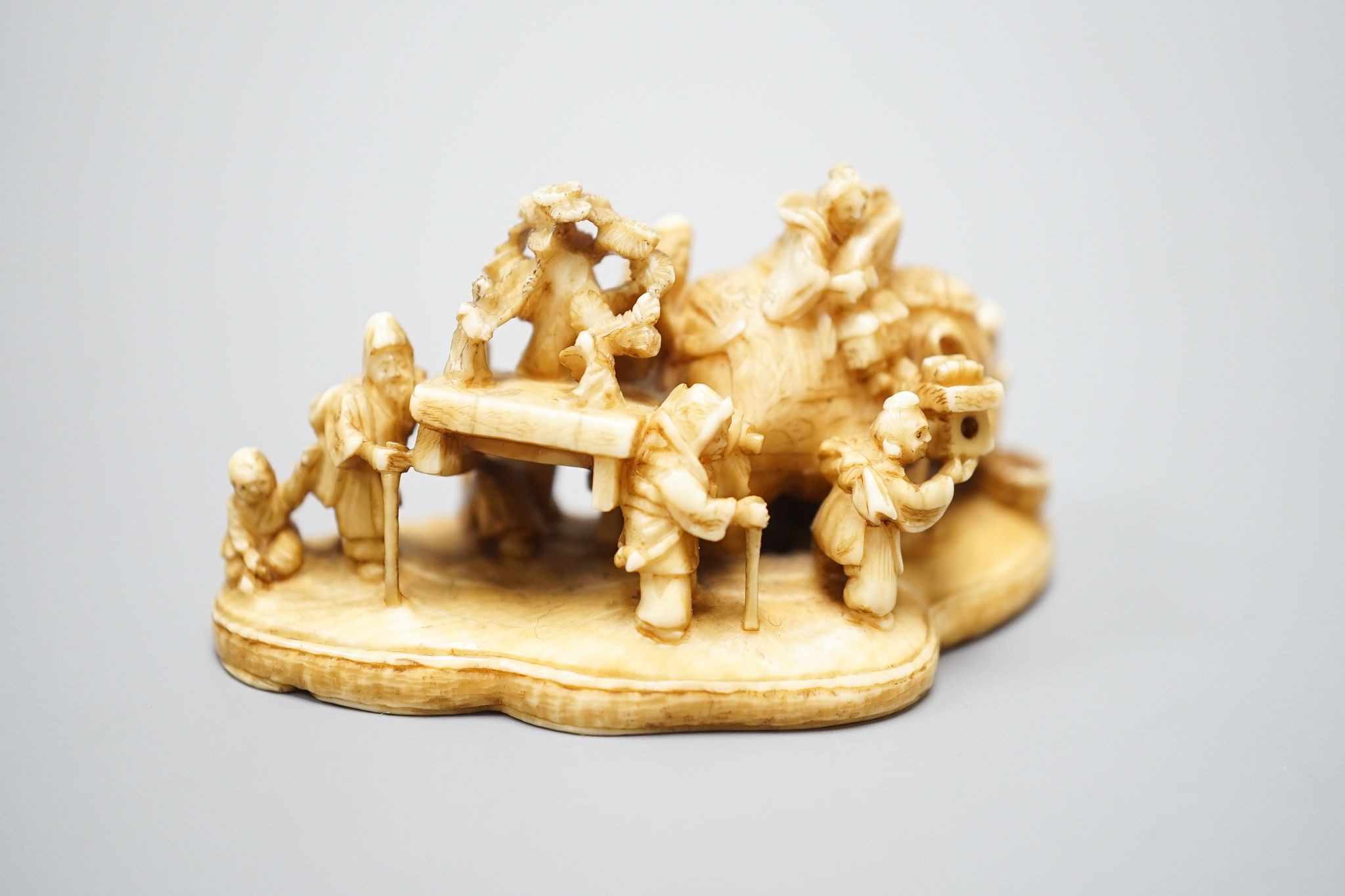 A Japanese carved ivory netsuke, mother of pearl inset to base with signature 'Gyokuzan', Meiji period, 6cm wide